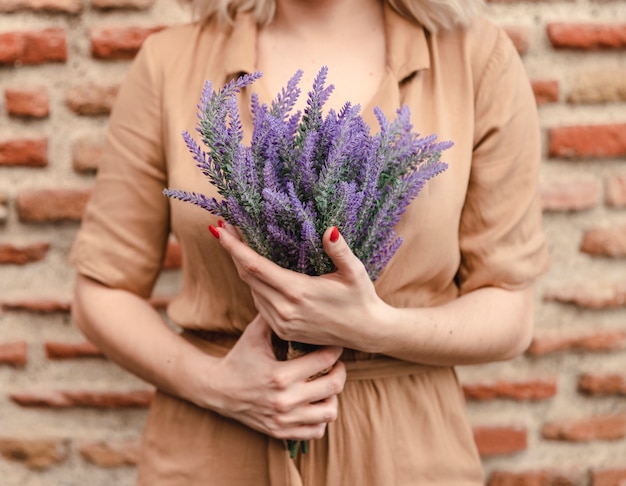 Gratis foto vrouw met boeket van lavendel bloemen