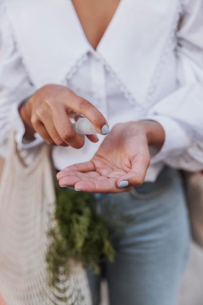 Vrouw met boodschappentassen met handdesinfecterend middel