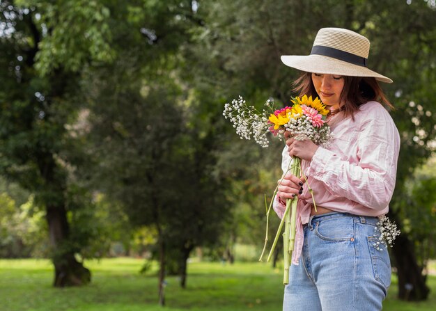 Vrouw met bos bloemen in park