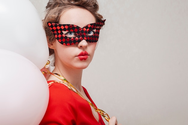 Vrouw met Carnaval-masker en ballons middelgroot schot