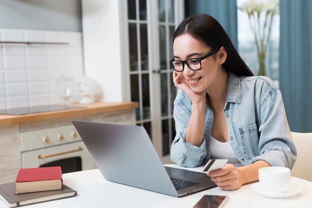 Vrouw met creditcard en online winkelen op laptop