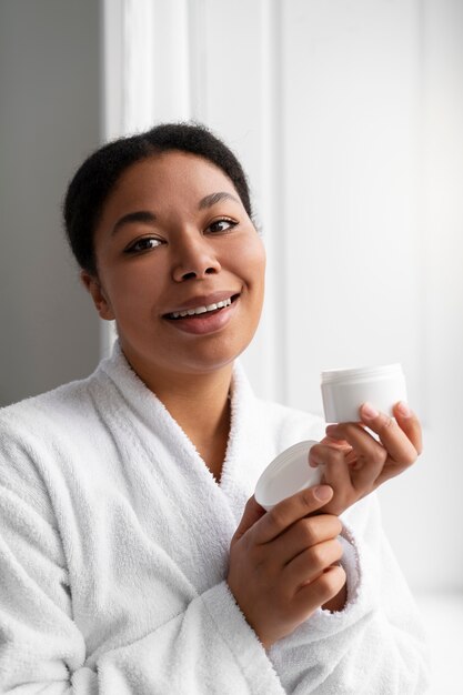 Vrouw met crème container vooraanzicht