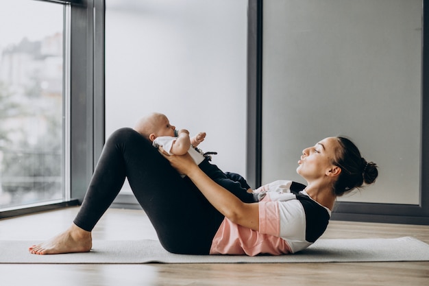 Vrouw met de praktijkyoga van de babyjongen