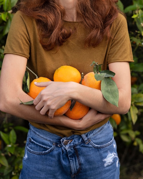 Vrouw met een bos sinaasappels orange