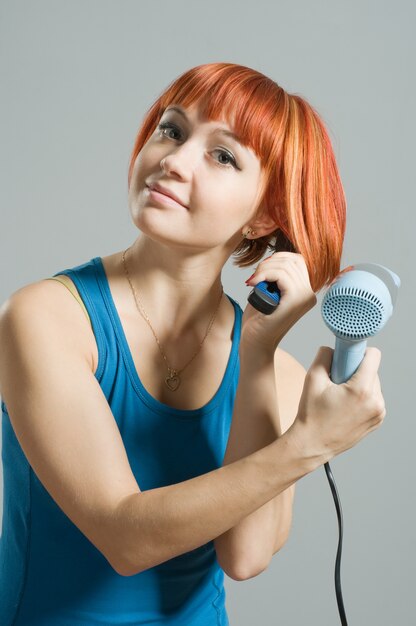 Vrouw met een haardroger en een haarborstel