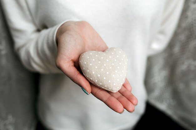 Vrouw met een hart-vormige stenen in handen