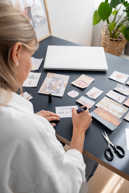 Gratis foto vrouw met een hoge hoek die een visiebord maakt