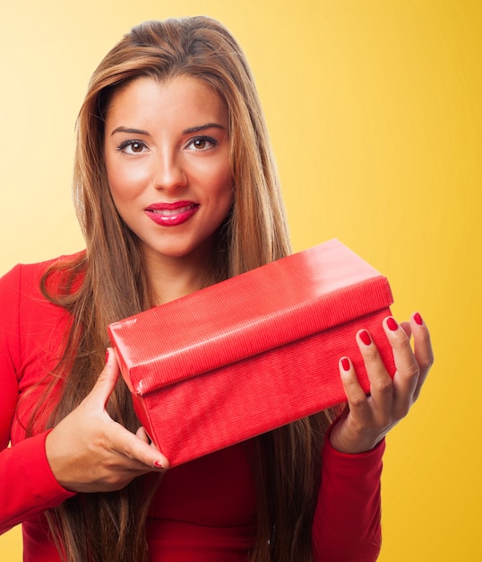 Vrouw met een rode doos op een gele achtergrond