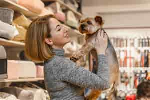 Gratis foto vrouw met een schattige kleine hond in de dierenwinkel