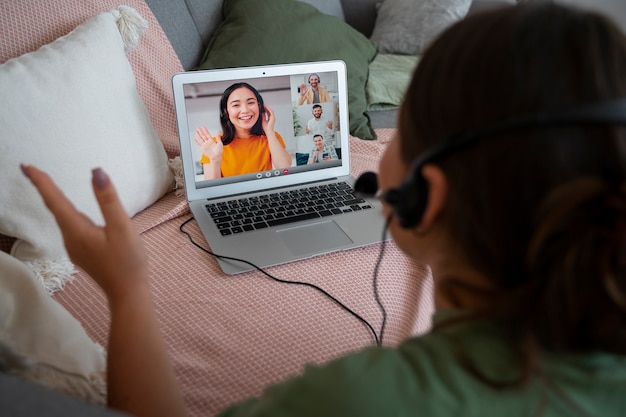 Vrouw met een videogesprek thuis op een laptop met headset