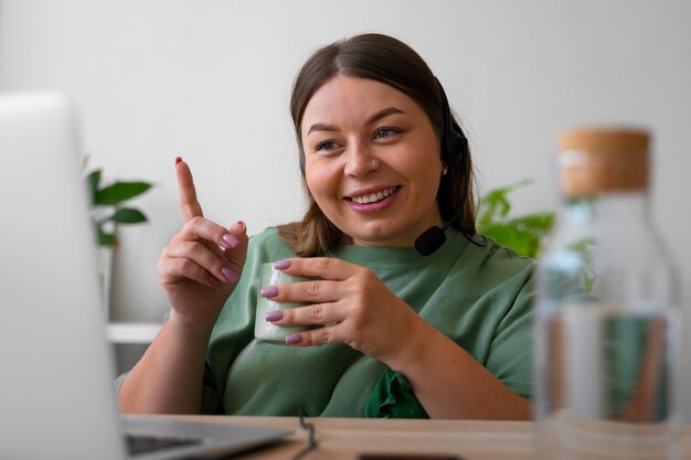 Vrouw met een videogesprek thuis op een laptop met headset