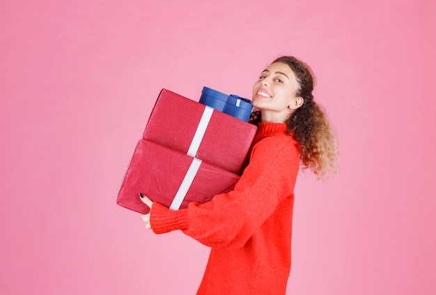 vrouw met een voorraad grote geschenkdozen.