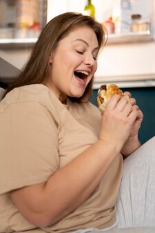 Vrouw met eetstoornis die fastfood probeert te eten