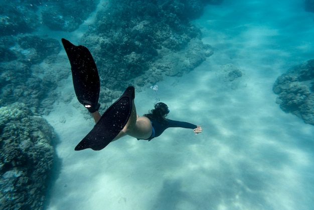 Vrouw met flippers die in de oceaan zwemmen