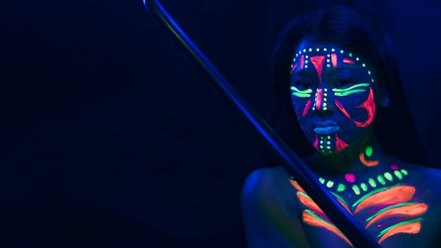 Vrouw met fluorescerende make-up en kopie ruimte