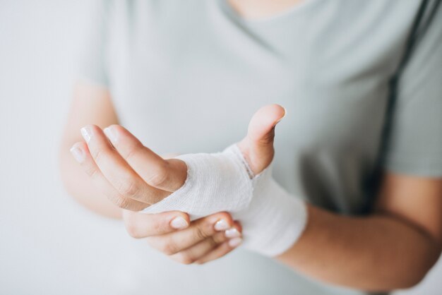 Vrouw met gaasverband gewikkeld om haar hand