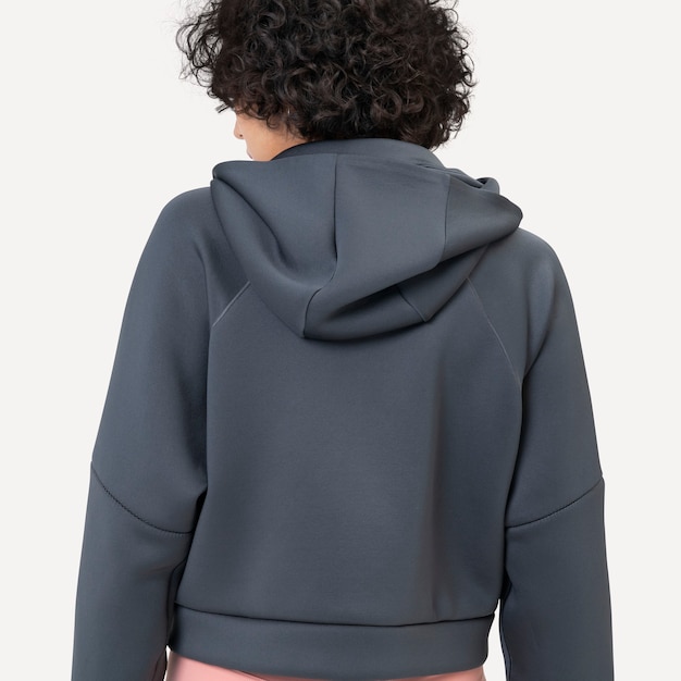 Vrouw met grijze hoodie voor wintermode studio shoot achteraanzicht