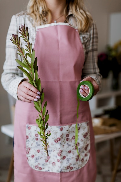 Gratis foto vrouw met groen lint en plant bijsnijden