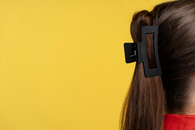 Gratis foto vrouw met grote haarklem zijaanzicht