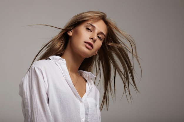 Vrouw met haar dat in de lucht vliegt, draagt mannenshirt