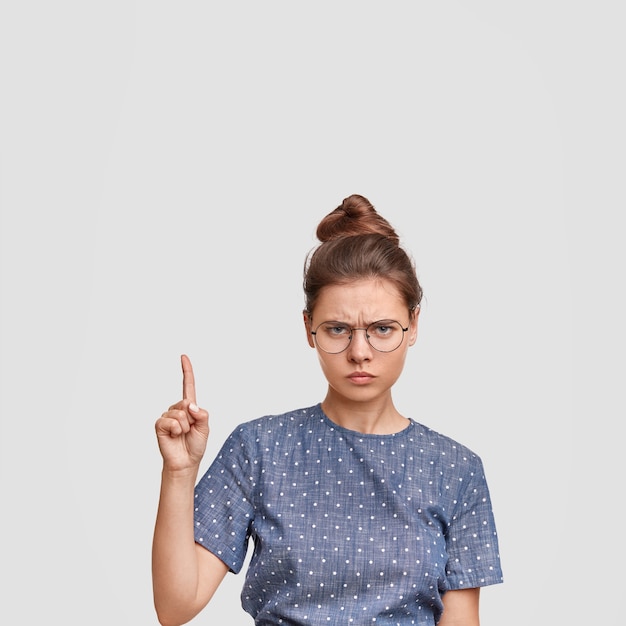 Vrouw met haar in een broodje dat polka dot blouse draagt