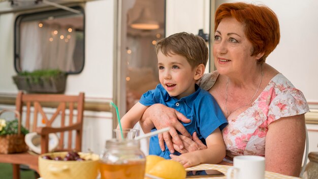 Vrouw met haar kleinzoon naast een caravan