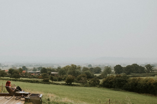 Vrouw met haar koffie die buiten op het platteland zit