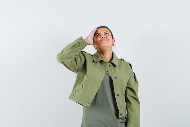vrouw met hand boven het hoofd terwijl het opzoeken in jas, t-shirt en op zoek vrolijk