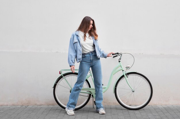 Vrouw met het stuur van de fiets buitenshuis