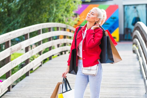 Vrouw met het winkelen pakketten op voetgangersbrug