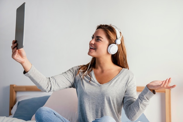 Vrouw met hoofdtelefoon die tablet gebruikt