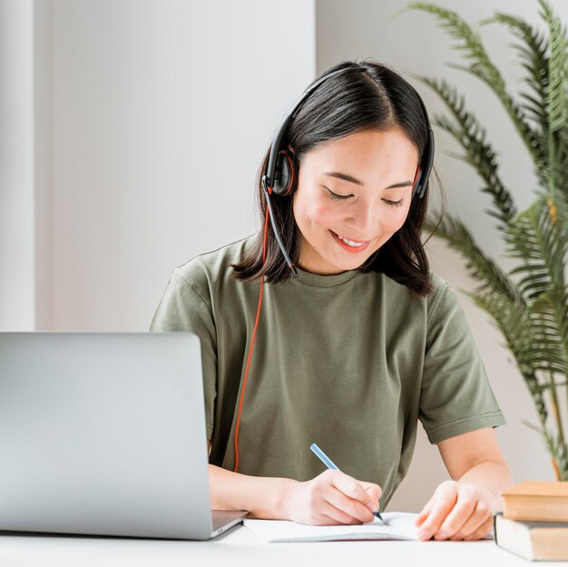 Vrouw met hoofdtelefoon die videogesprek op laptop heeft