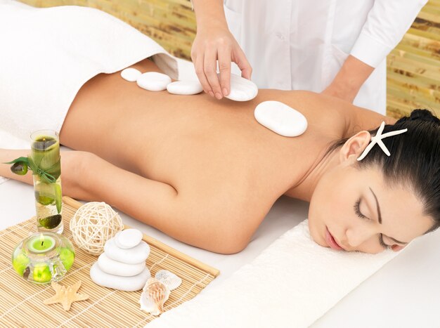 Vrouw met hot stone spa massage van rug in de schoonheidssalon