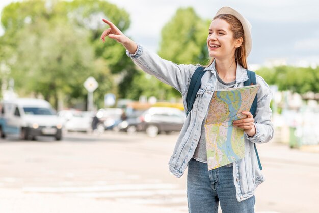 Vrouw met kaart die haar vinger in de lucht richt