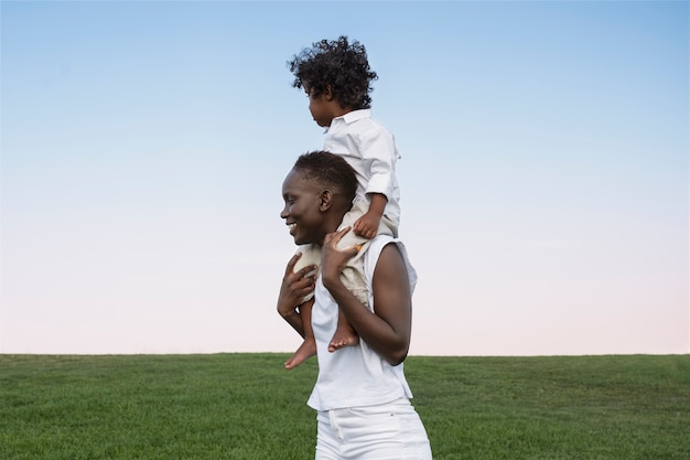 Gratis foto vrouw met kind op schouders zijaanzicht