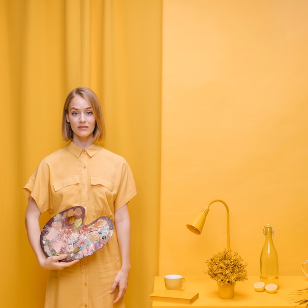 Vrouw met kleurenpalet in een gele scène