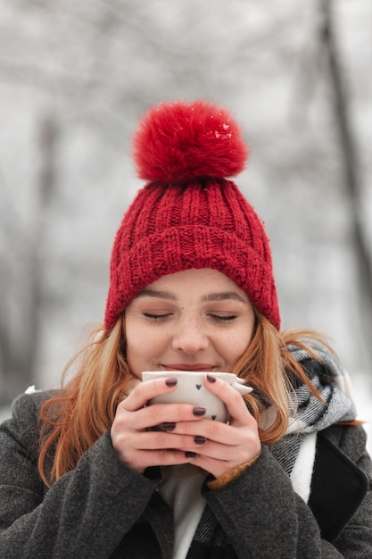 Gratis foto vrouw met kopje thee met haar ogen dicht