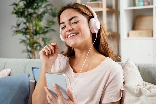 Vrouw met koptelefoon met behulp van mobiel