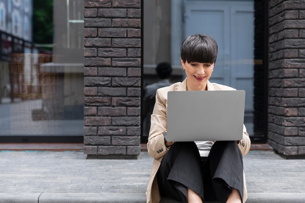 Vrouw met kort haar die haar laptop controleert