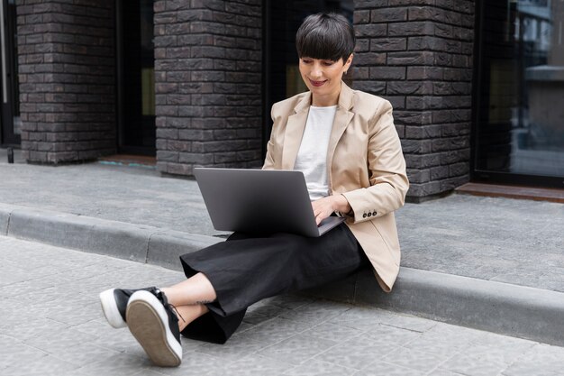 Vrouw met kort haar die haar laptop controleert