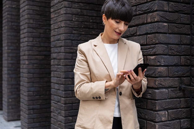 Vrouw met kort haar die haar telefoon vasthoudt