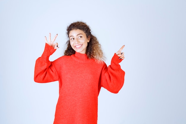 Vrouw met krullende haren die naar boven wijst.