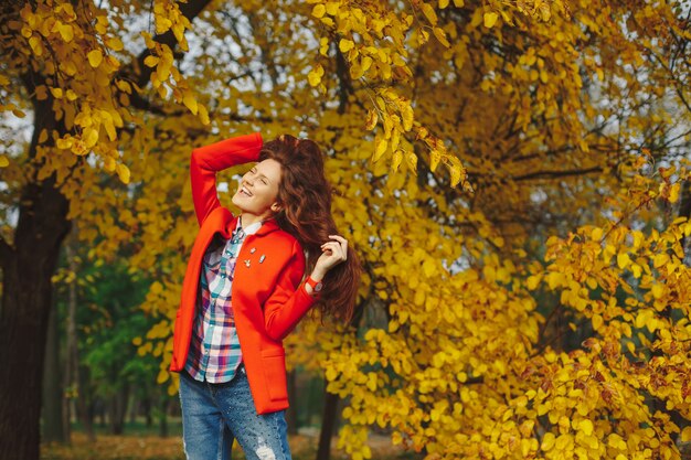 vrouw met lang golvend haar genieten van de herfst in het park.