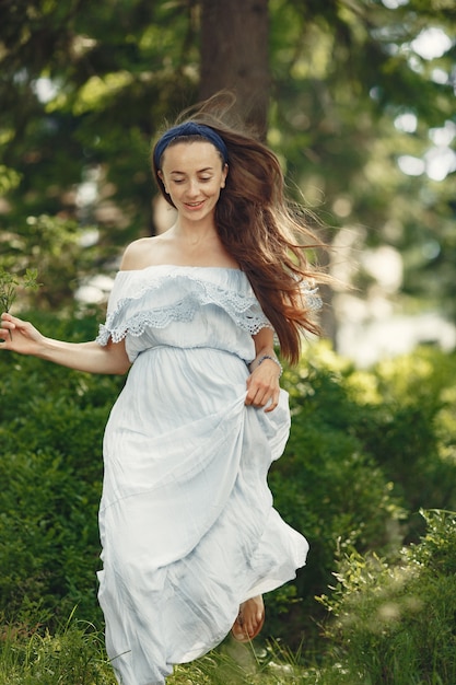 Vrouw met lang haar. Dame in een blauwe jurk. Meisje met ongerepte natuur.