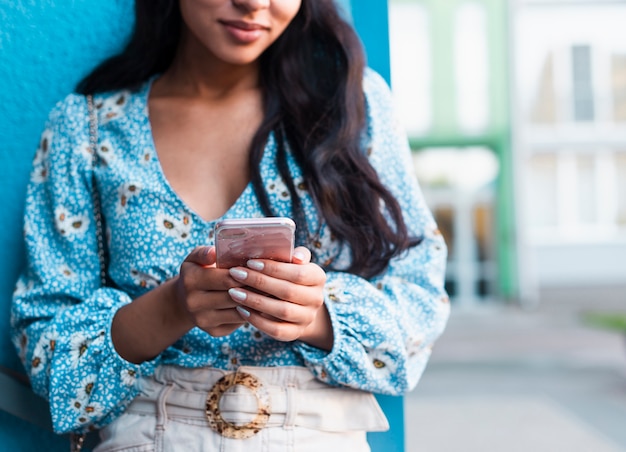 Gratis foto vrouw met lang haar die haar telefoon met behulp van