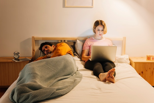 Vrouw met laptop dichtbij de droevige mens