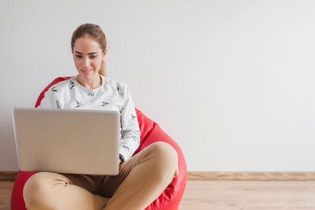 Gratis foto vrouw met laptop op fauteuil