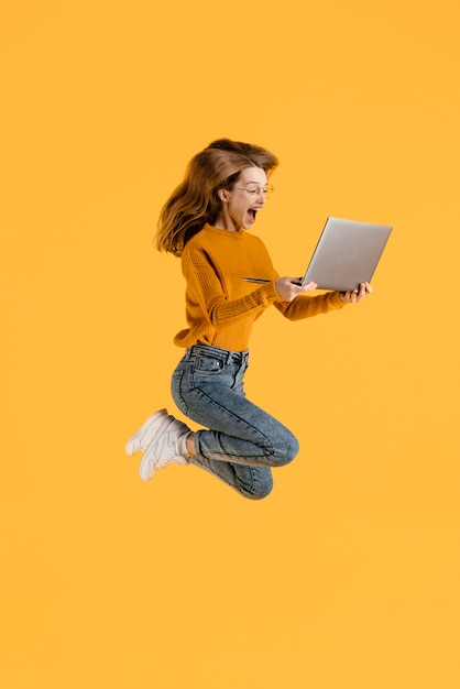 Gratis foto vrouw met laptop springen
