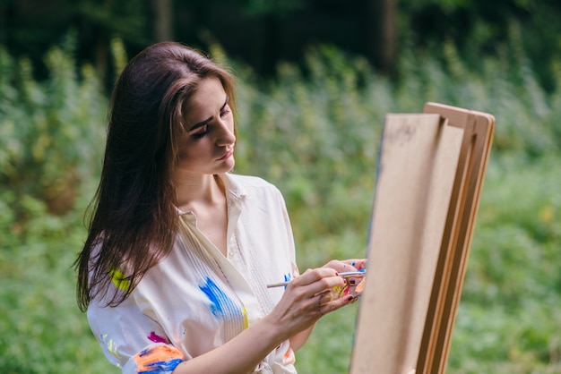 Vrouw met losse haren het schilderen van een canvas