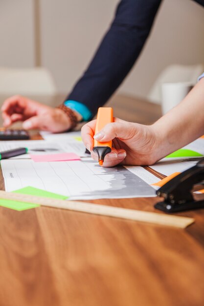 Vrouw met markeringspen leunend op bureau